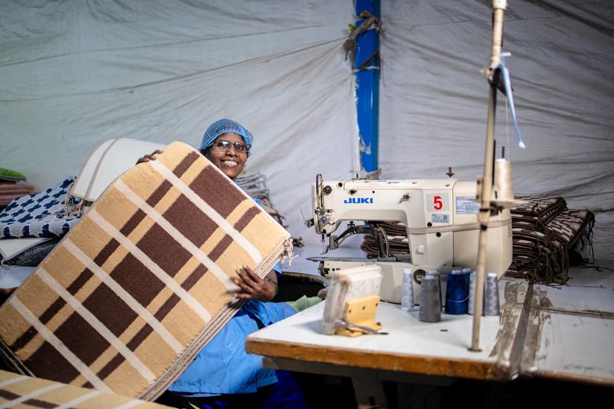 Artisane devant une piqueuse industrielle